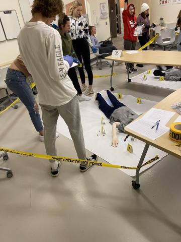 crime scene with mannequin and 6 students assessing