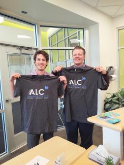 Bell Photography holding up ALC shirts